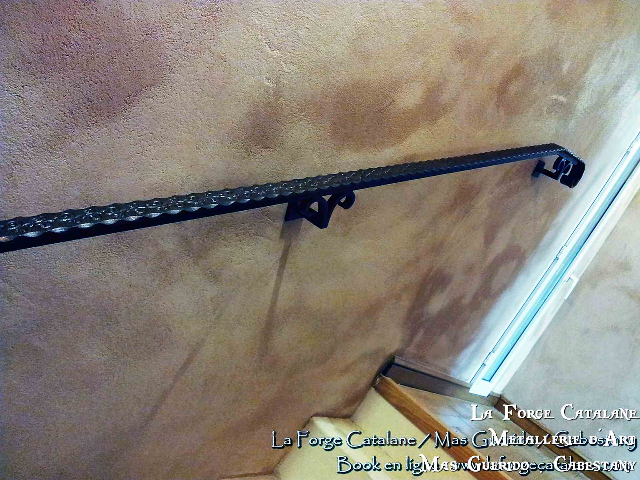 main courante martele avec cavalier de fixation en forme de volutes forge catalane.jpg